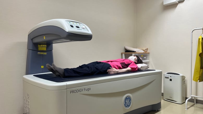 X線骨密度測定装置　DPX-BRAVO（GE社製）  当院では、脊椎の圧迫骨折や大腿骨頚部骨折を予防する目的で、一般的に普及している手や手関節で簡易的に測定を行うのではなく、直接腰椎と股関節の正確な骨密度測定を行い、骨粗鬆症などの治療に役立てております。検査は患者様に動いて頂く必要がなく、腰椎・股関節が一度に測定可能で、約10分で終了します。