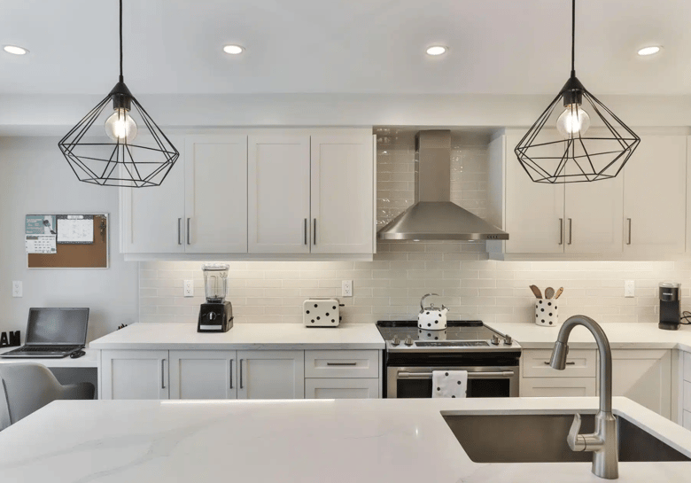 The kitchen is a bright, spacious area with sleek white cabinets and a large island that doubles as a cozy breakfast bar.