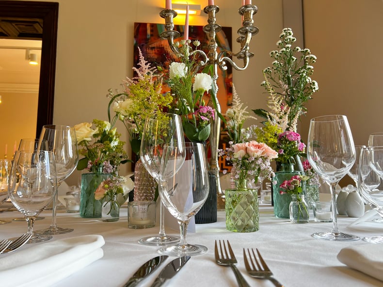 Tischdekoration mit Blumen, Kerzen und Kerzenleuchtern