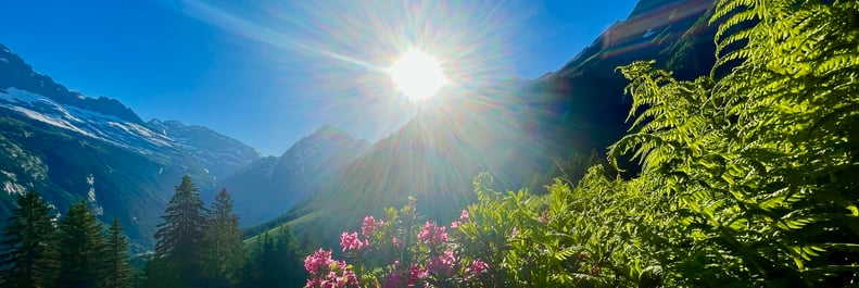 eine malerische Berglandschaft, mit Sonnenstrahlen, die durch die Wolken brechen und einen klaren Blick auf den Horizont freigeben.