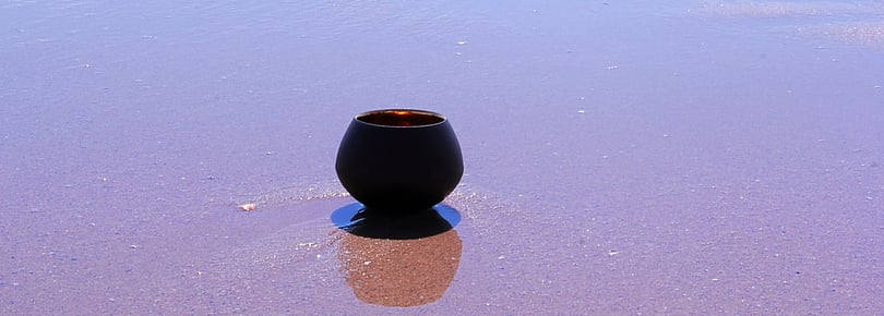 Teetasse am Strand im Wasser