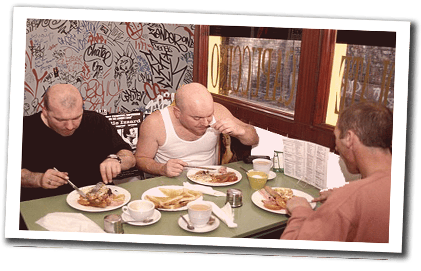bald men eating English breakfast in a typical British cafe