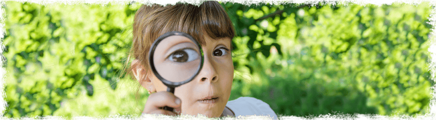 Mädchen schaut durch eine Lupe, Glückskinder