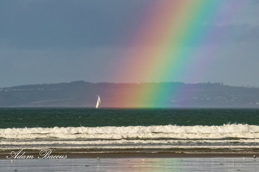 Voilier dans l'arc en ciel sur la mer.