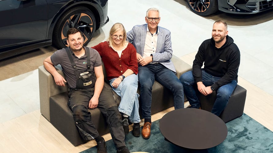 Tim Fischer, Birgit Fischer, Dirk Fischer, Sebastian Fischer sitzend auf einem Sofa im Autohaus Fischer.