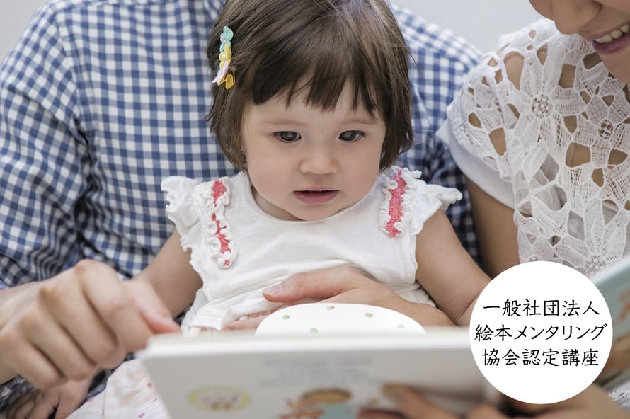 ［写真］小さな女の子が絵本の読み聞かせに耳を傾けている様子／一般社団法人絵本メンタリング協会認定講座