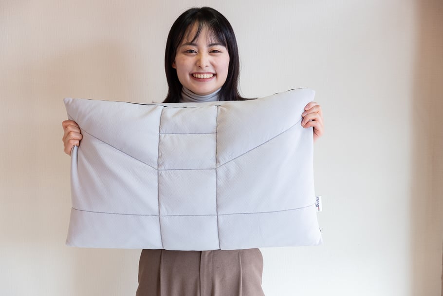 おすすめのオーダー枕をもって微笑む女性
