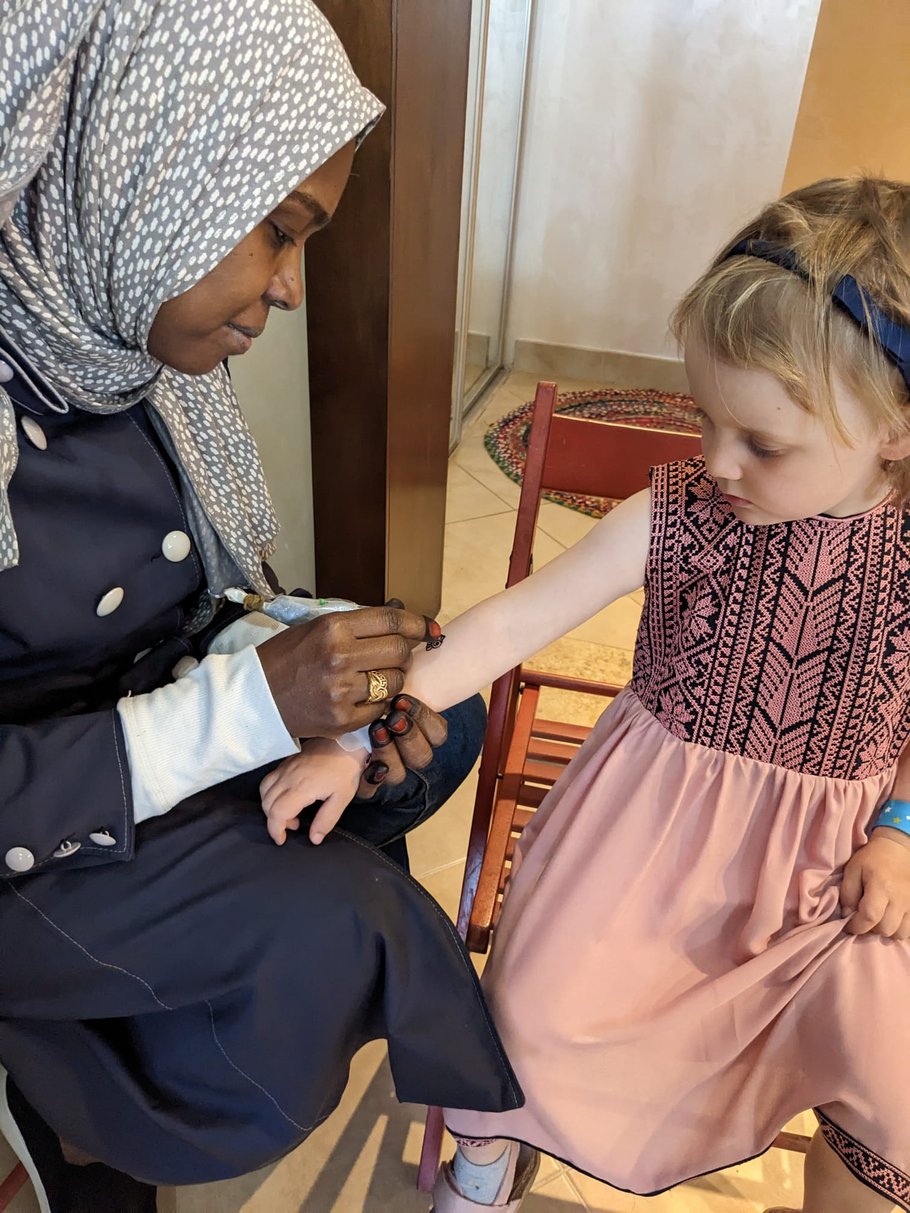 Eine Henna-Expertin malt das Tattoo