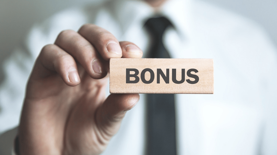 Mann der ein Schild hochhält auf dem Bonus Steht