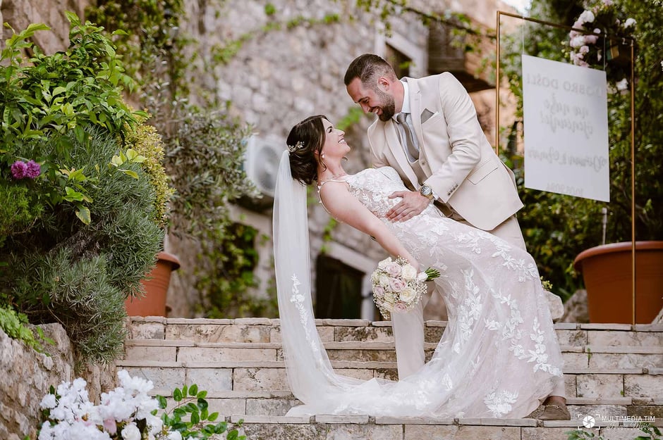 A bride and groom celebrating their wedding day, embracing lovingly in the historic gardens of Palata Venezia, Ulcinj