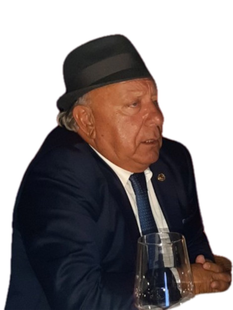 Gani Resulbegović, Founder and Owner of Palata Venezia, wearing cap and formal attire, seated at a table