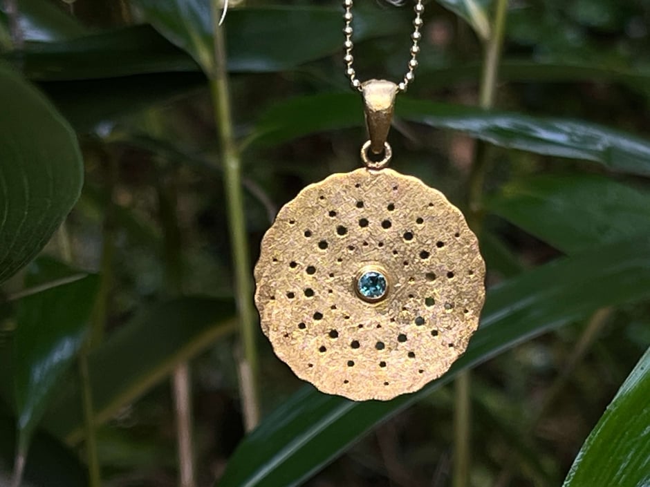 Goldene Kette mit handgeschmiedeten runden Amulett mit grünen Turmalin