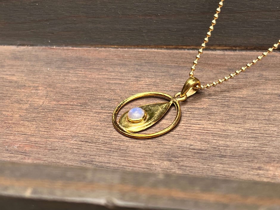Kette mit Anhänger goldene Flamme Symbol in dem ein runder Mondstein Cabochon gefasst ist in vergoldeten Silber