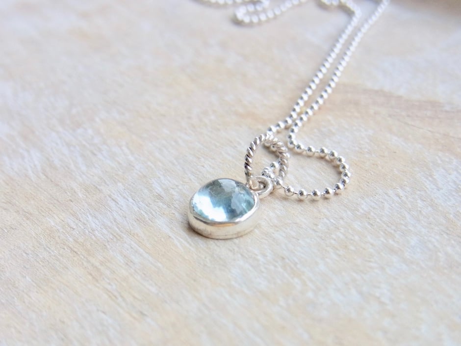 Feine Kette mit transparenten hellblauen runden Aquamarin Anhänger in Silber gefasst