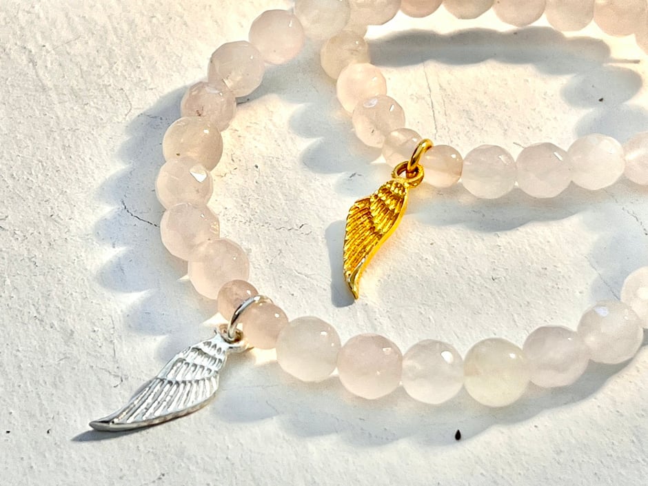 Rosenquarz Armband mit geschliffenen Kugeln und einem kleinen Engelsflügel Anhänger in Silber oder gold