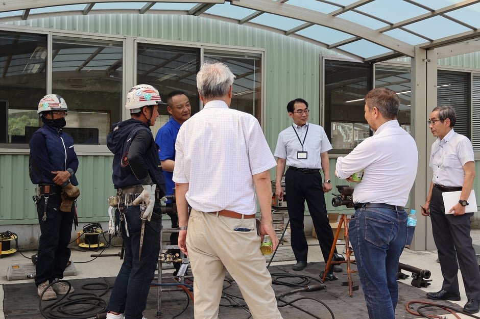 技術の話に花が咲く圧接部の職人と教授たち