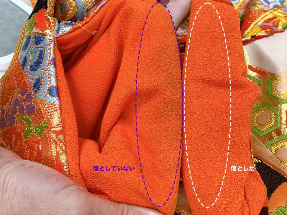 着物の黒い汚れが落ちている部分と、落ちていない部分の比較をした画像。