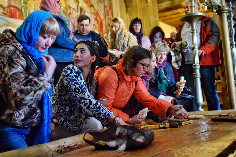 Saint Sépulcre, pèlerins touchants la pierre où Jésus fut lavé.