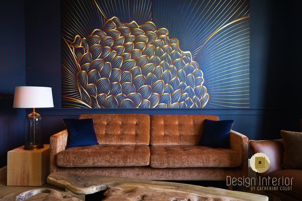 Aménagement d'un salon avec un papier peint panoramique bleu et un canapé en velours terracotta dans une majestueuse maison de maître