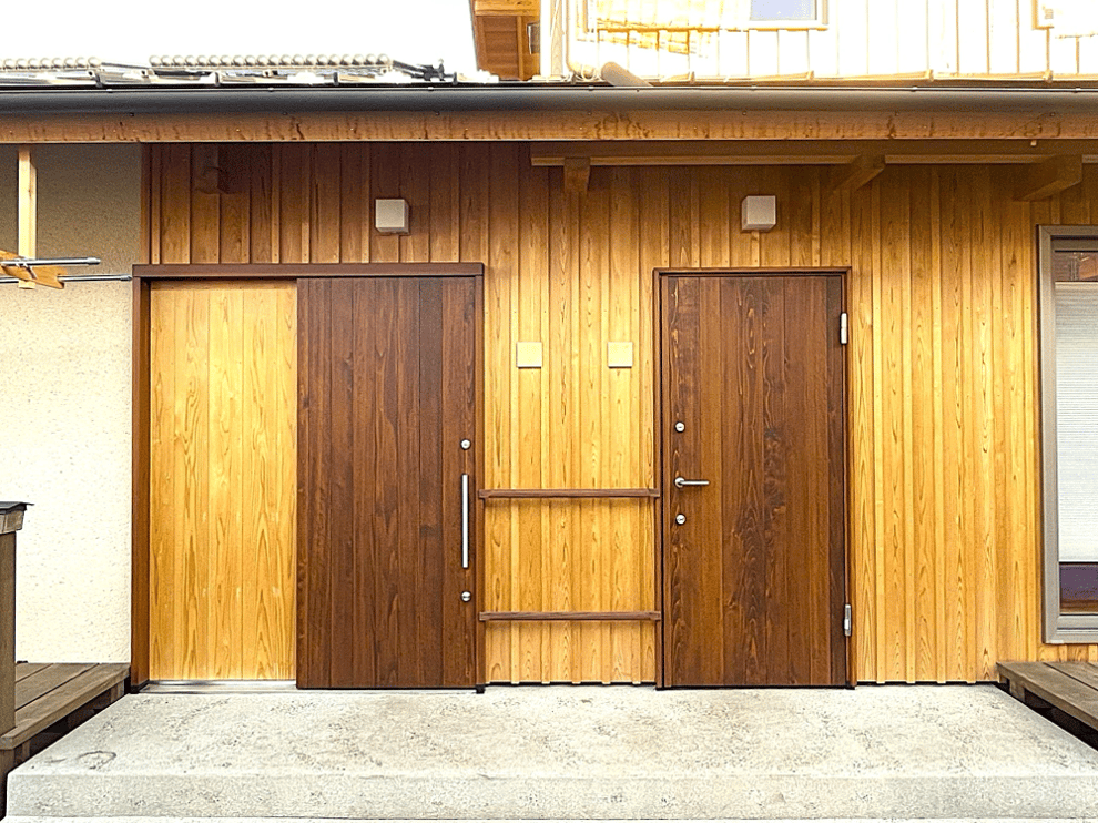 木製の玄関。木の温もりが家族を迎えます。2つの玄関の間には傘掛けを作成してもらいました。